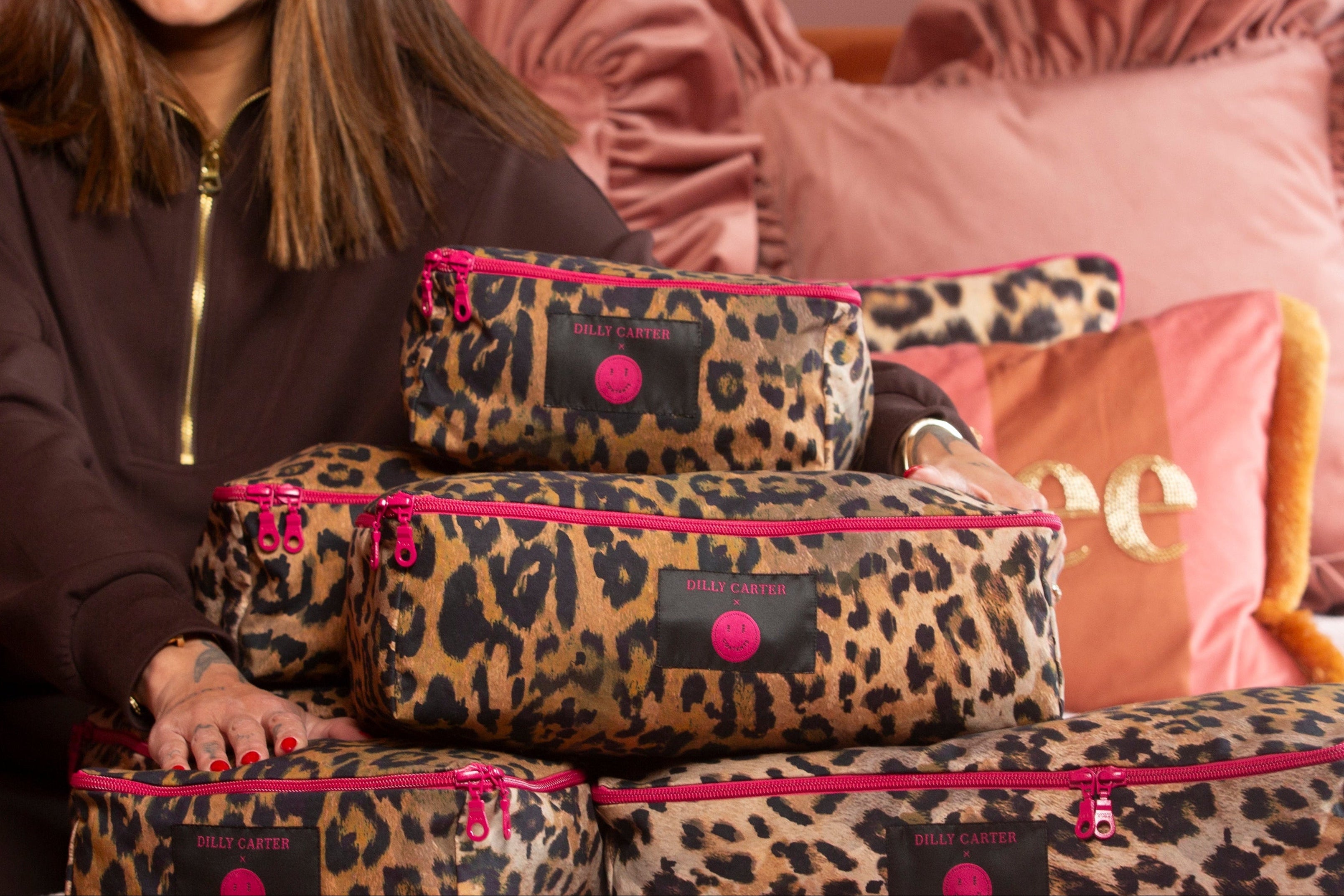 Woman sitting on a bed with leopard print makeup bags